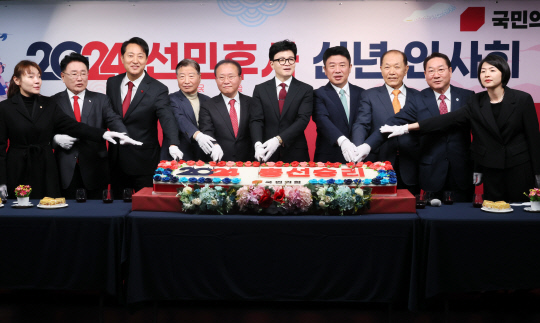 국민의힘 한동훈 비상대책위원장과 윤재옥 원내대표, 오세훈 서울특별시장 등 참석자들이 1일 서울 여의도 국민의힘 중앙당사에서 열린 신년인사회에서 '2024 총선승리'라는 글씨로 장식된 떡 케이크를 자르고 있다.<연합뉴스>